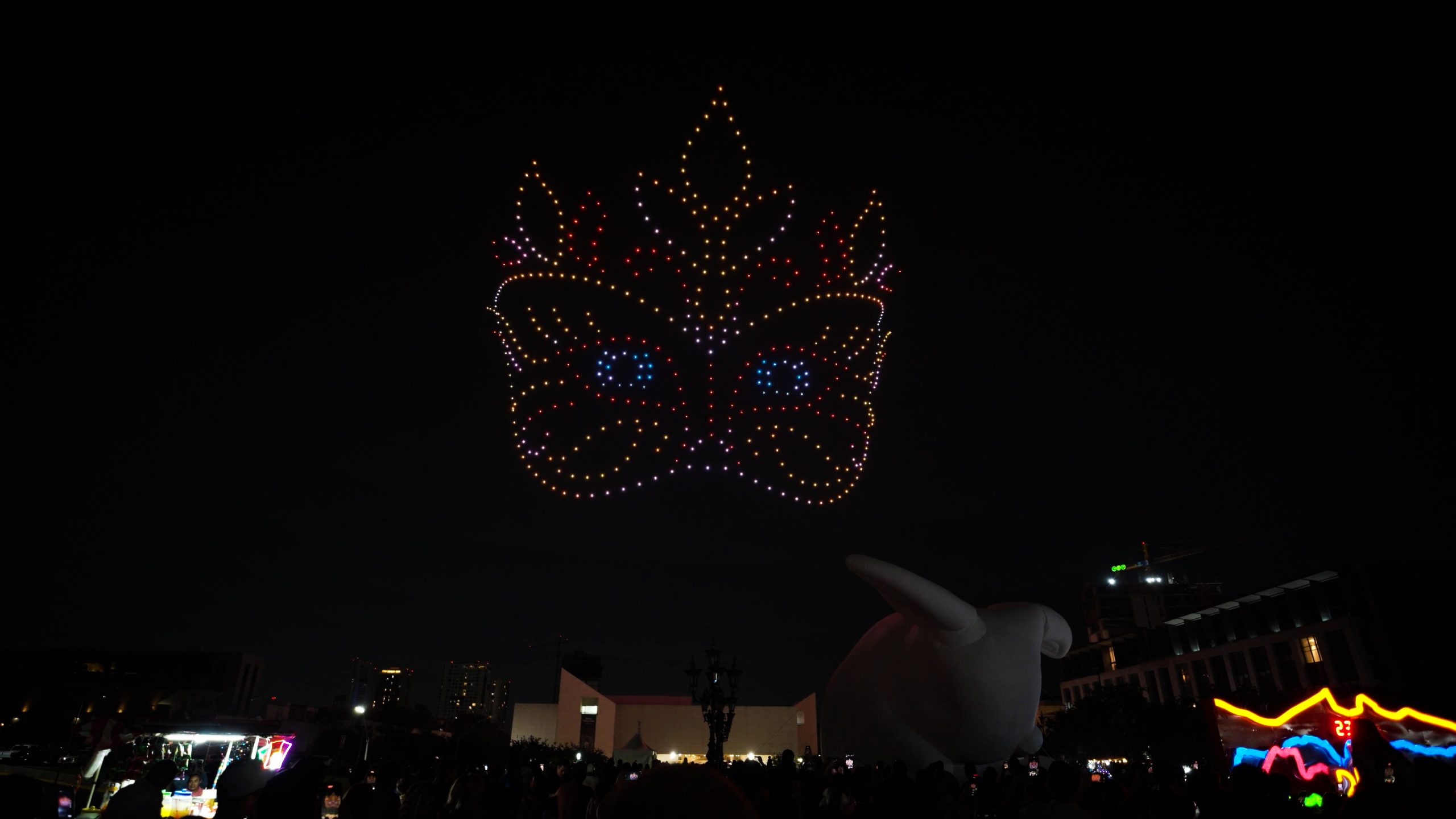 Lumasky light show at the Santa Lucía Festival in Monterrey, where 500 drones form a bright carnival mask with patterns and glowing eyes in the night sky.
