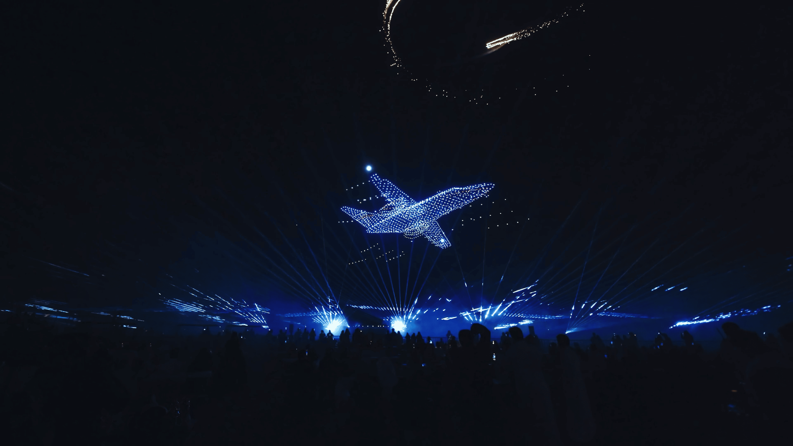 During the Lumasky drone show at the Saudi Aviation Club Sun and Fun Airshow 2025, drones form a detailed image of an airplane hovering over the airfield site with laser and light effects in the night sky.