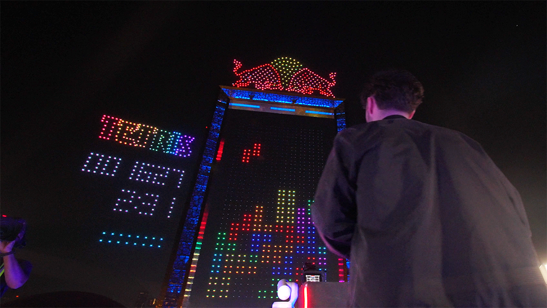At the Red Bull Tetris Final in Dubai event, a participant plays a giant Tetris on the facade of a building decorated with light graphics as part of the 4,000 Lumasky Drone Show.